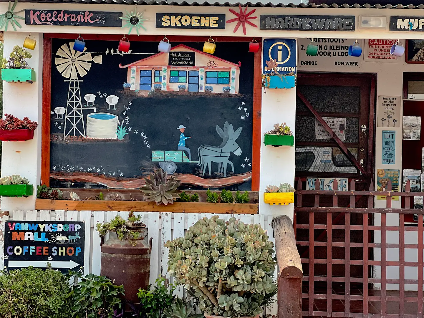Landsbykafé i Vanwyksdorp med et håndmalt veggmaleri i tavlestil av en vindmølle og en eselvogn